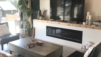 Una Smart TV, una chimenea, libros, un reproductor estéreo