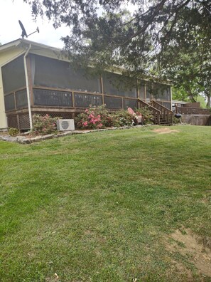 A residential property with a screened porch, a covered outdoor area, and a landscaped garden.