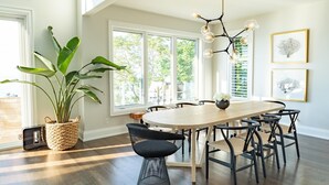A dining area with a large table, multiple chairs, a hanging light fixture, and a potted plant. - Rare Waterfront Gem In Blue Mountain/Collingwood! Less than 2hrs from Toronto! (The Blue Mountains)