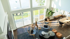 A spacious room with large windows, a dining area, and a cozy seating area with a plant. - Rare Waterfront Gem In Blue Mountain/Collingwood! Less than 2hrs from Toronto! (The Blue Mountains)