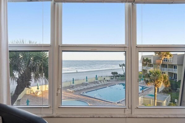 A view of a beachside pool area with a clear sky. - W/D in Unit, Ocean Views Galore, Spectacular Sunrise & Sunset from property (Saint Augustine Beach Florida)