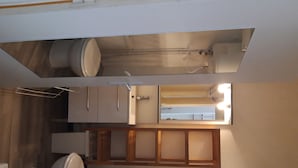 A compact kitchen with a sink, cabinets, and a mirror. - Lovely studio in the heart of the historic center (Montpellier)