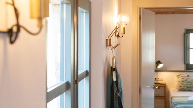 A room with a bed, a nightstand, a lamp, and a wall-mounted light fixture. - Bravissimo Raïms Penthouse, with 2 bedrooms (Girona)