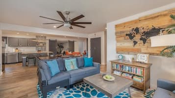 A modern living room with a sofa, coffee table, and bookshelf.