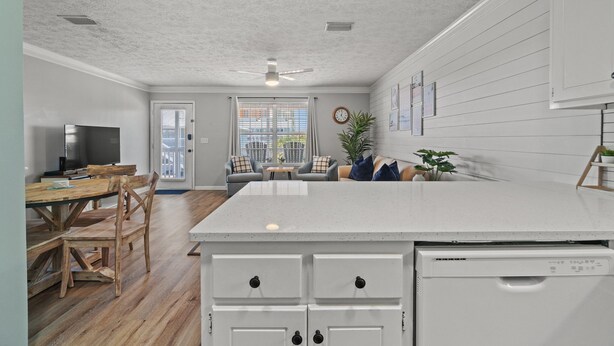 A modern kitchen with a central island, wooden dining table, and chairs.
