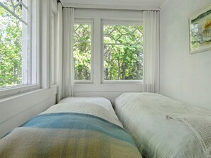 A room with two beds, a window with curtains, and a painting on the wall. - Piennarpää by Interhome (Saarijärvi)