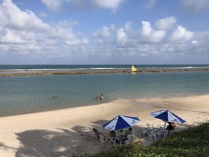 Na praia, espreguiçadeiras, toalhas de praia 