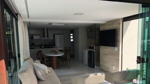 En modern inredning med en soffa, stolar, ett matbord och ett köksområde.