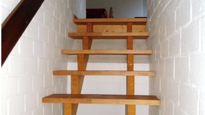 Een houten trap met witte bakstenen muren.