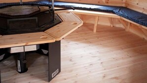 Un dormitorio de buhardilla acogedor, con estufa de leña, ventana y camas literas.
