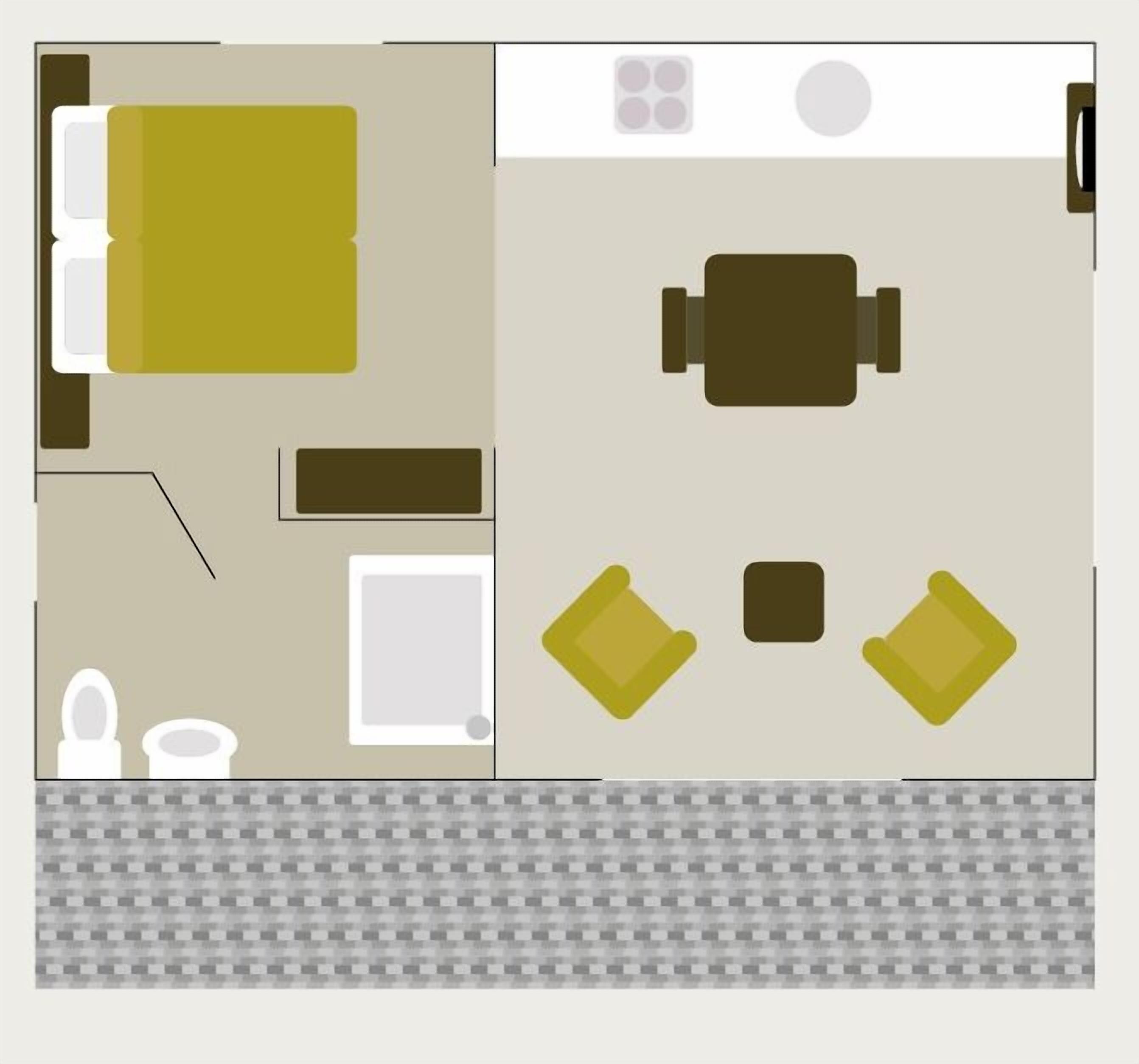 A hotel room with a bed, a desk, a chair, a small table, a toilet, and a sink.
