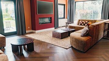A modern living room with a fireplace, a sofa, a coffee table, and a large window.