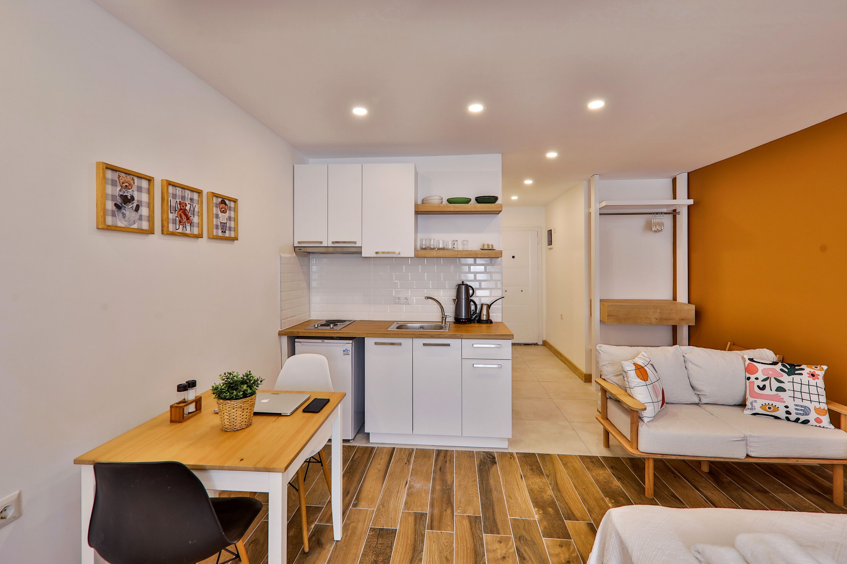 Un espacio habitable compacto con kitchenette, comedor y sofá.