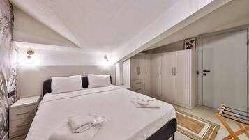 A bedroom with a bed, bedside tables, a wardrobe, and a bench.