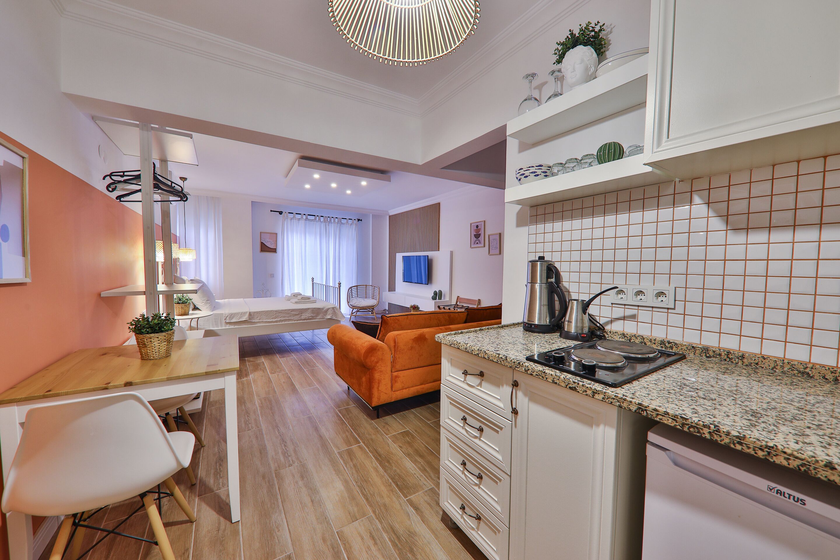 A modern kitchen with white cabinets, a granite countertop, and a built-in dishwasher.