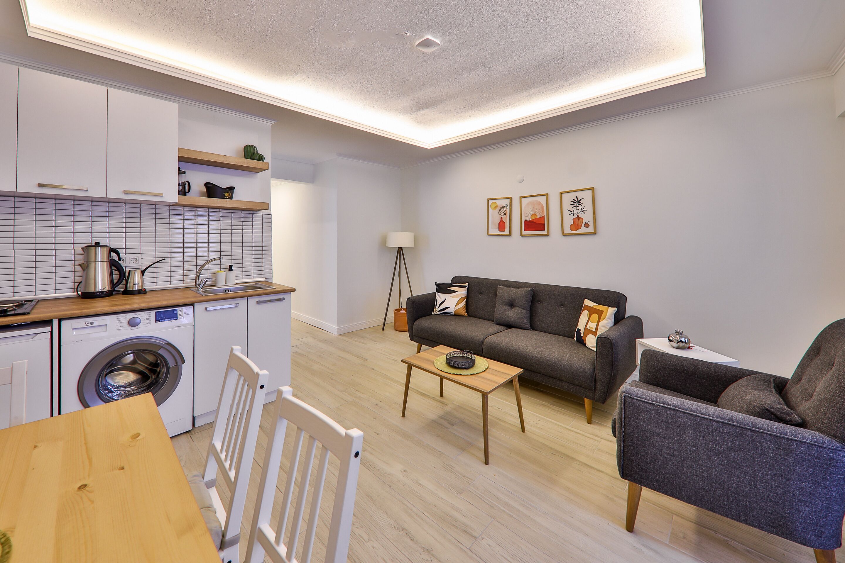 Um apartamento moderno com cozinha, sofá e área de jantar.
