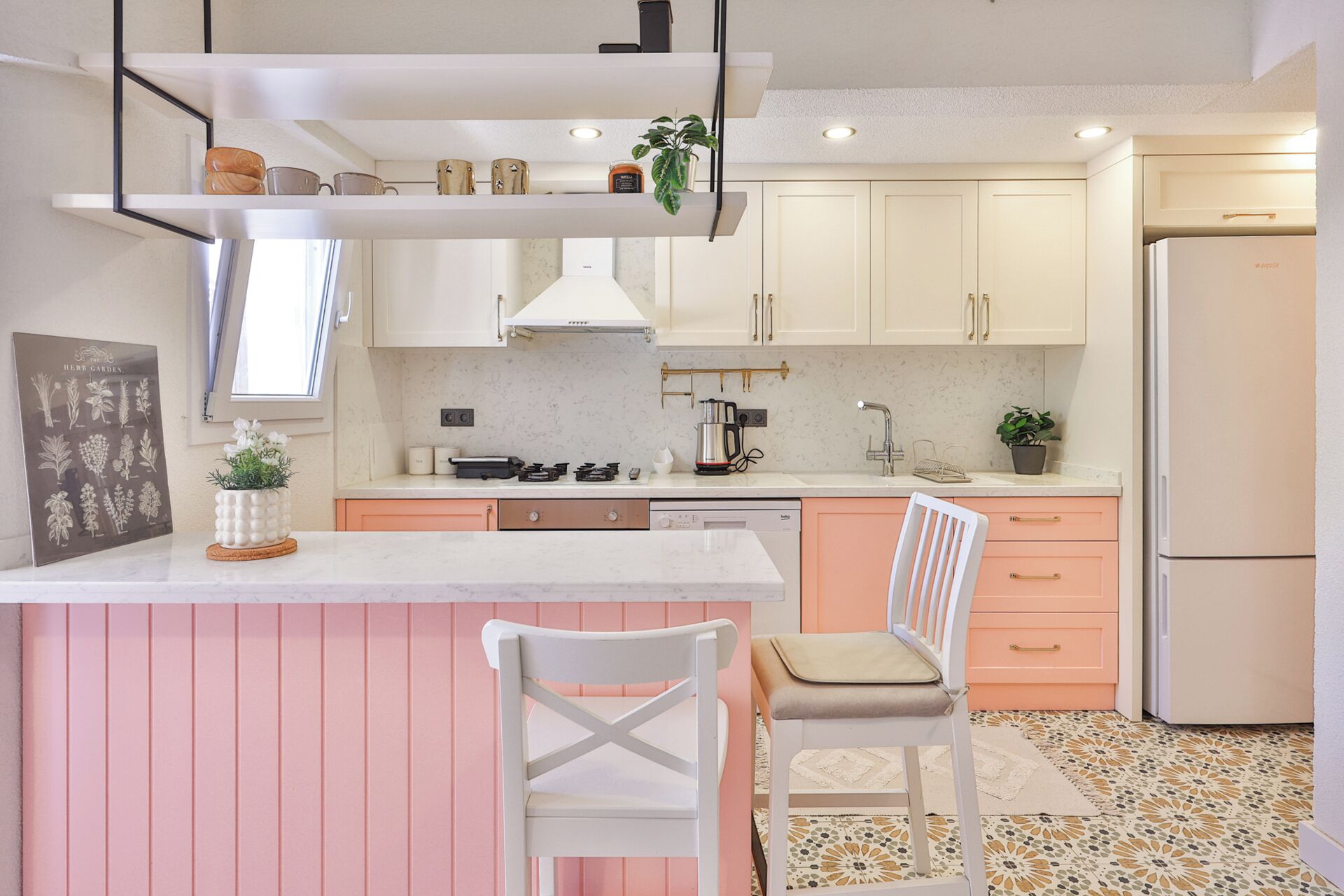 A modern kitchen with white cabinets, a central island, and a refrigerator.