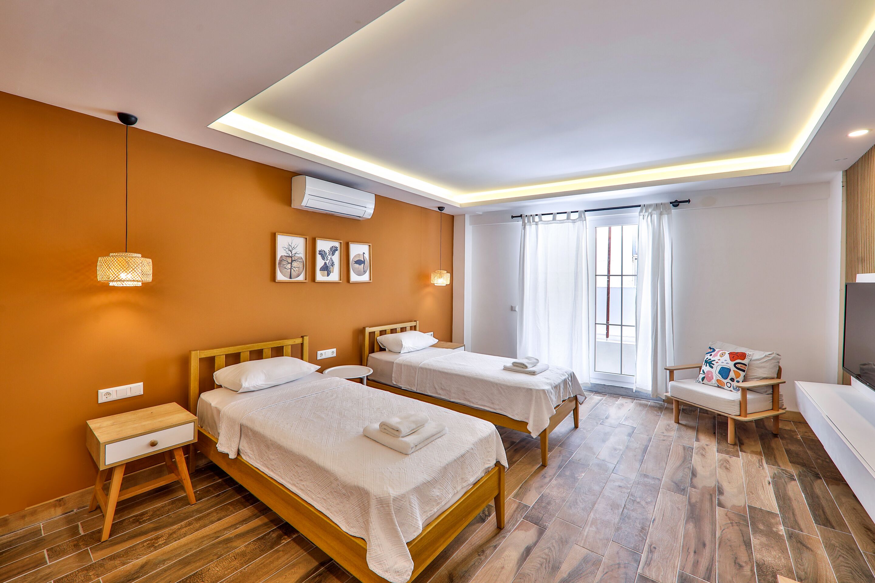 A hotel room with two beds, a small seating area, and a TV.