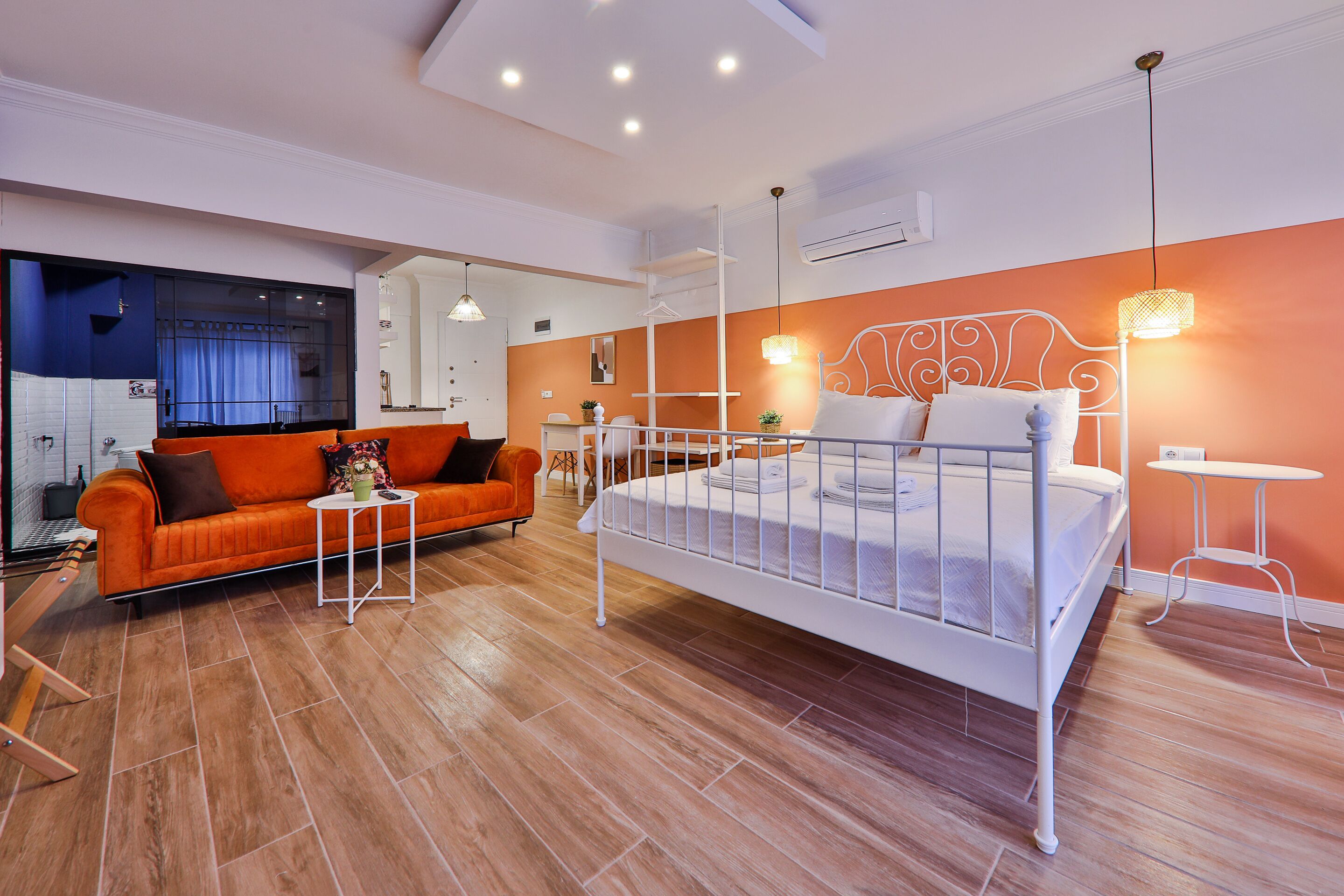 A modern bedroom with a bed, a sofa, and a small table.