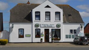 A white building with a sign reading "Restaurant - Pension Zur Brücke". - Room 4 - Pension Restaurant Zur Brücke (Wittmund)