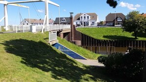 A residential area with a white bridge, houses, and a small water channel. - Room 4 - Pension Restaurant Zur Brücke (Wittmund)