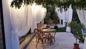 An outdoor patio area with white drapes, wicker furniture, and potted plants. - Exclusive Villa with Private Pool Sleeps 12 - 6 Rooms (Castelbaldo)