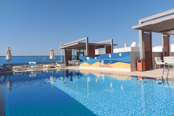 Piscine extérieure, parasols de plage, chaises longues