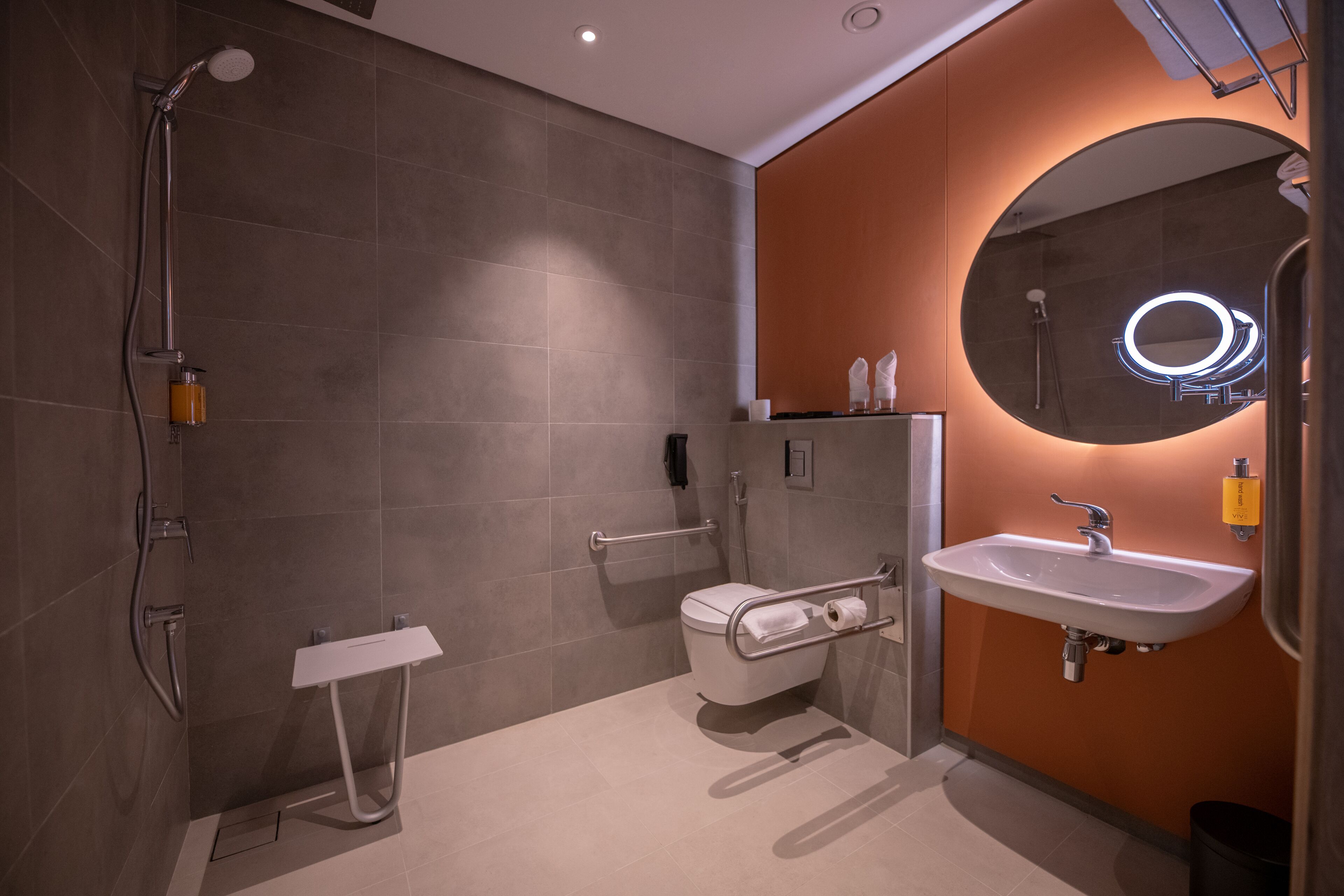 A modern bathroom with a shower, toilet, and sink.
