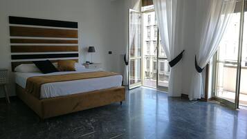 Un dormitorio moderno con una cama grande, una mesita de noche y vistas al exterior.