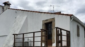 A white building with a stone staircase leading to a wooden door.
