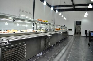 A buffet setup with multiple food display cases and a seating area with chairs.