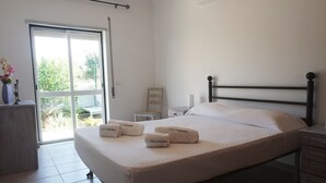 Et hotelværelse med en seng, et natbord, en stol og et skrivebord.