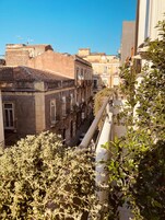 Una stretta via fiancheggiata da edifici con balconi e antenne paraboliche, tipica di un quartiere residenziale.