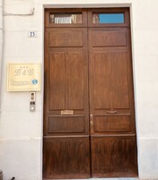 Un'ampia porta in legno a due ante con un cartello sopra che riporta la scritta "B&B Stramond".
