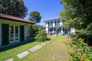A two-story house with a red-tiled roof, green shutters, and a stone pathway leading to the entrance. - Villa Victor 100m from sea (Massa)