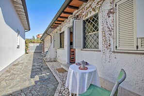 Sit and enjoy the serene atmosphere in this charming outdoor seating area with a round table and a green chair.