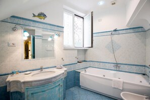 Een bad/douchecombinatie, een haardroger, een bidet, handdoeken