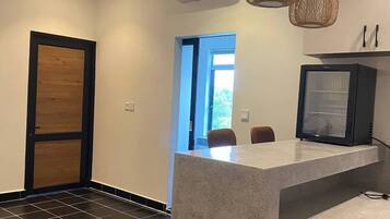 A modern kitchen with a built-in island, black tiled flooring, and pendant lighting.