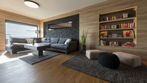 A modern living room with a grey sofa, a coffee table, and a bookshelf. - Traumhaus 6 Personen,150m²,sauna,wanne,kamine,terrassen,garten,grill,sky TV (Neukieritzsch)