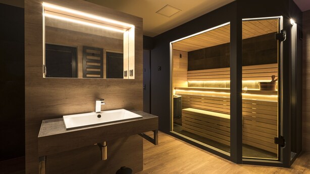 A modern bathroom with a large mirror, a sink, and a sauna. - Traumhaus 6 Personen,150m²,sauna,wanne,kamine,terrassen,garten,grill,sky TV (Neukieritzsch)