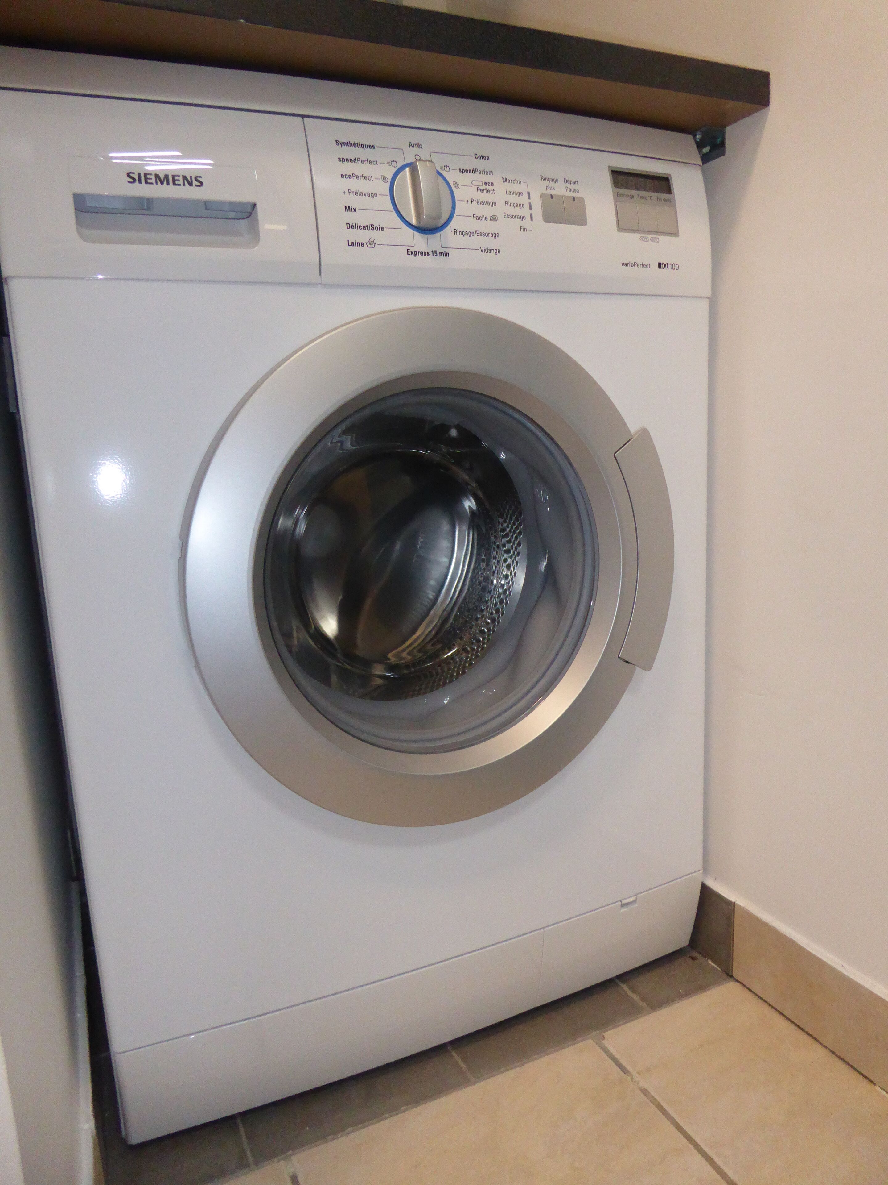 A Siemens washing machine with a control panel displaying various settings.