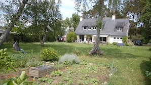 A house with a garden, a hammock, and a car parked in the driveway. - Quiet house for 8 near the beach (Locmariaquer)