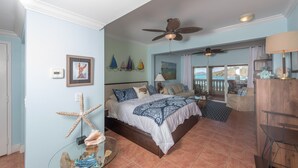 Un dormitorio con una cama, decoración de estrella de mar y vista al océano.