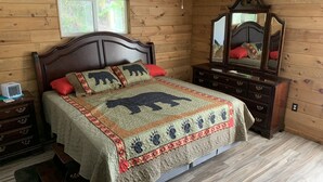 Une chambre à coucher aux murs lambrissés, comprenant un lit, une commode, un miroir et une fenêtre.