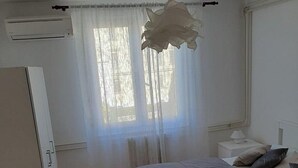 A bedroom with a bed, bedside table, lamp, and an air conditioning unit. - Adriatic Sea View Apartment ZOE (Rovinj)