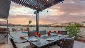 Un espace extérieur aménagé pour les repas, avec une piscine, des chaises et un barbecue.