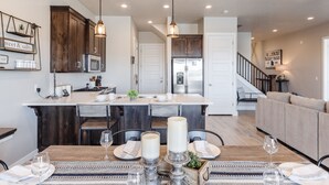 Une cuisine moderne avec des meubles en bois, un îlot central et des luminaires suspendus.