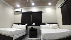 A bedroom with two beds, a nightstand, a ceiling fan, and a window with blinds. - Malda House (Dunmore Town)
