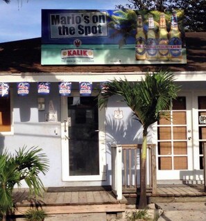 Welcome to Mario's on the Spot, where you can enjoy a cold Kalik beer on the porch.