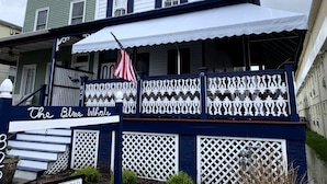 A building with a blue and white facade, a white awning, and a sign reading "The Blue Whale."